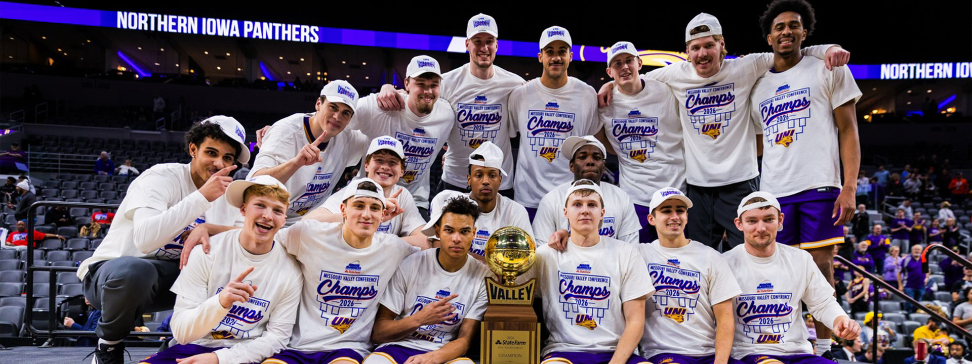 UNI men's basketball team celebrating on the court.