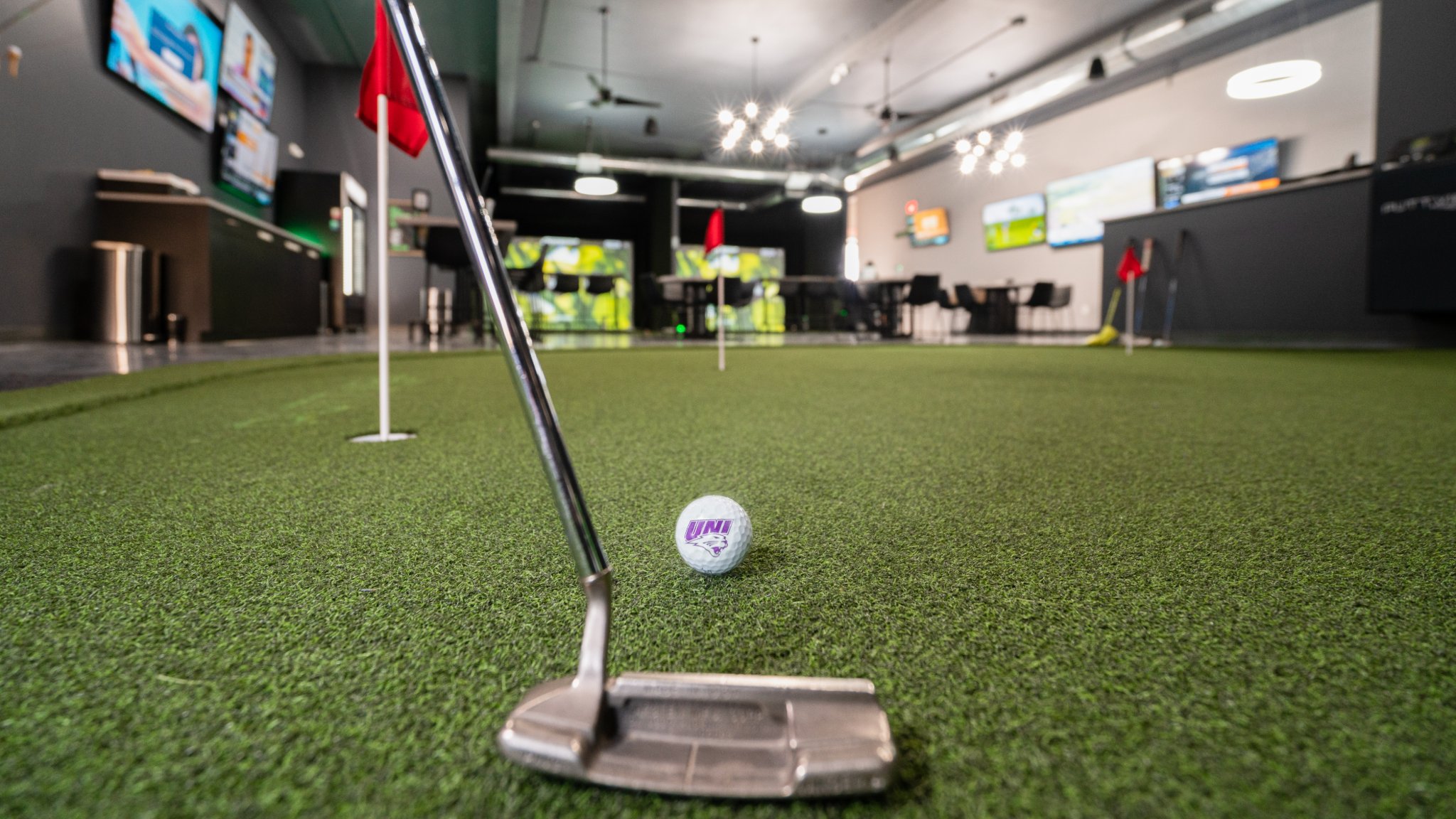 Golf club about to hit a UNI golf ball