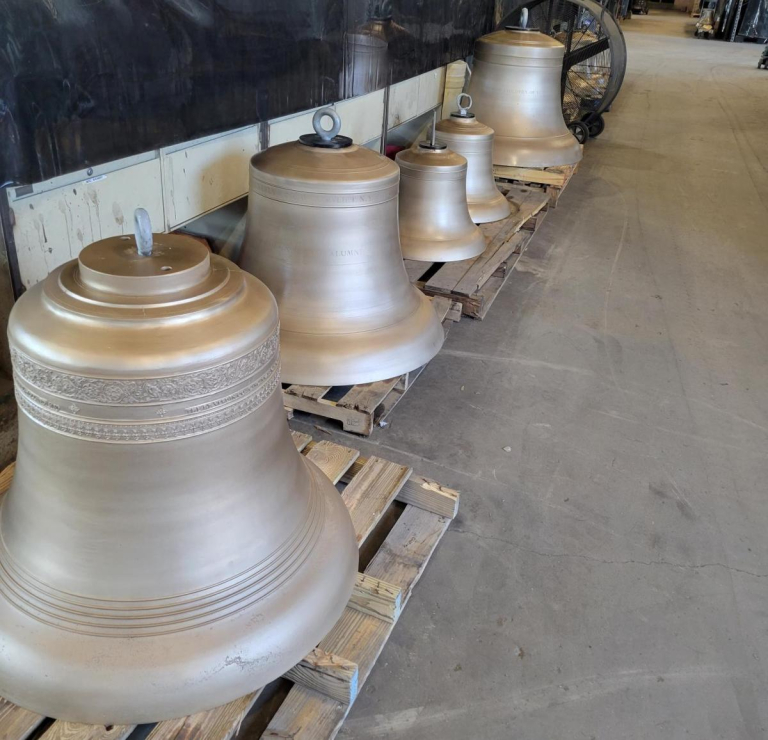 restored UNI Campanile bells waiting on palettes at The Verdin Company to be shipped home