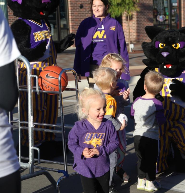Young UNI Panther children playing basketball in purple and gold clothing at Main Street Madness 2022