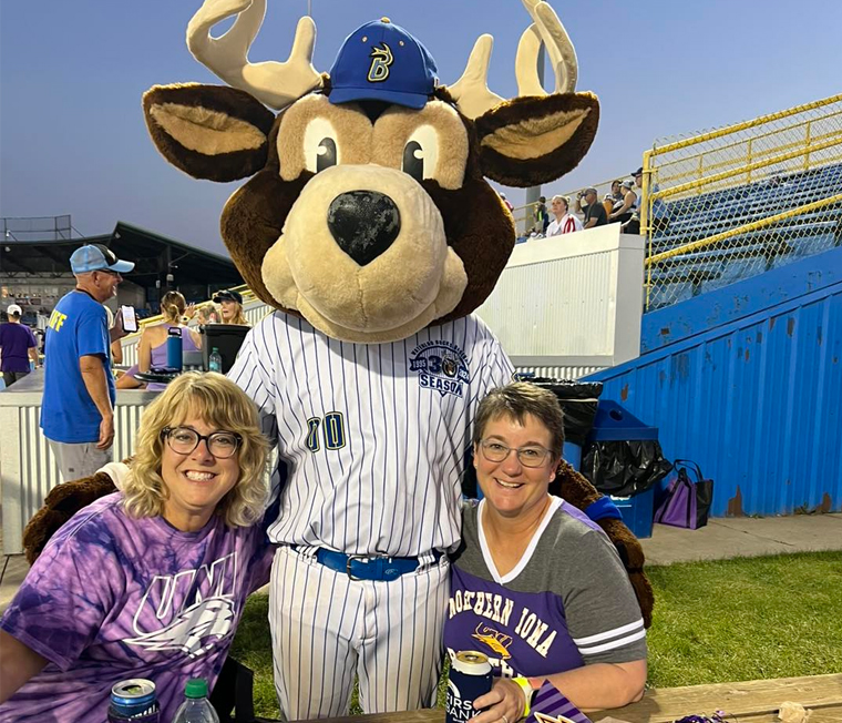 Two UNI alumni with the Waterloo Bucks mascot