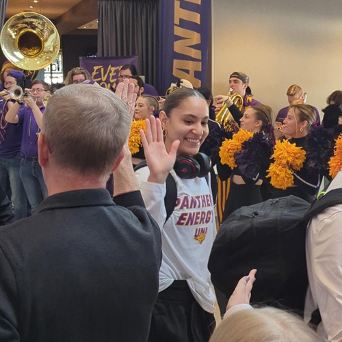 A UNI women's basketball player high fives President Nook at the 2024 team sendoff