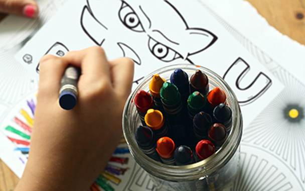 Close up of a child coloring a TC Panther coloring page