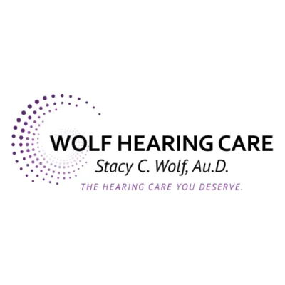 Wolf Hearing Care logo with purple dotted spiral and black text