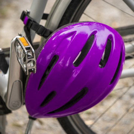Close up on a bicycle with a purple helmet hanging at the side