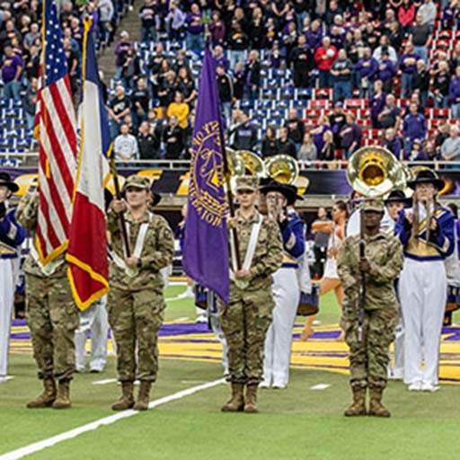 ROTC holding flag on UNI football field at game